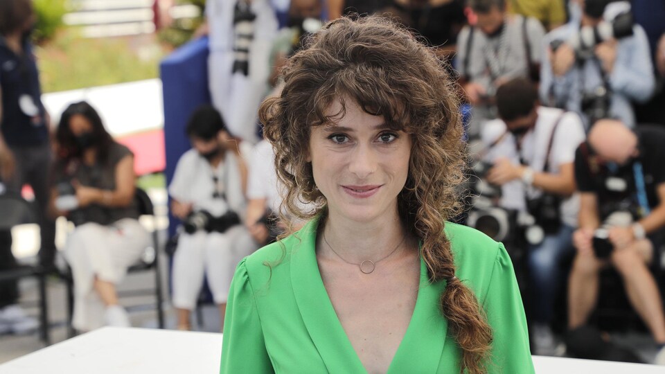 Une femme portant une robe vert pomme est photographiée à l'extérieur.