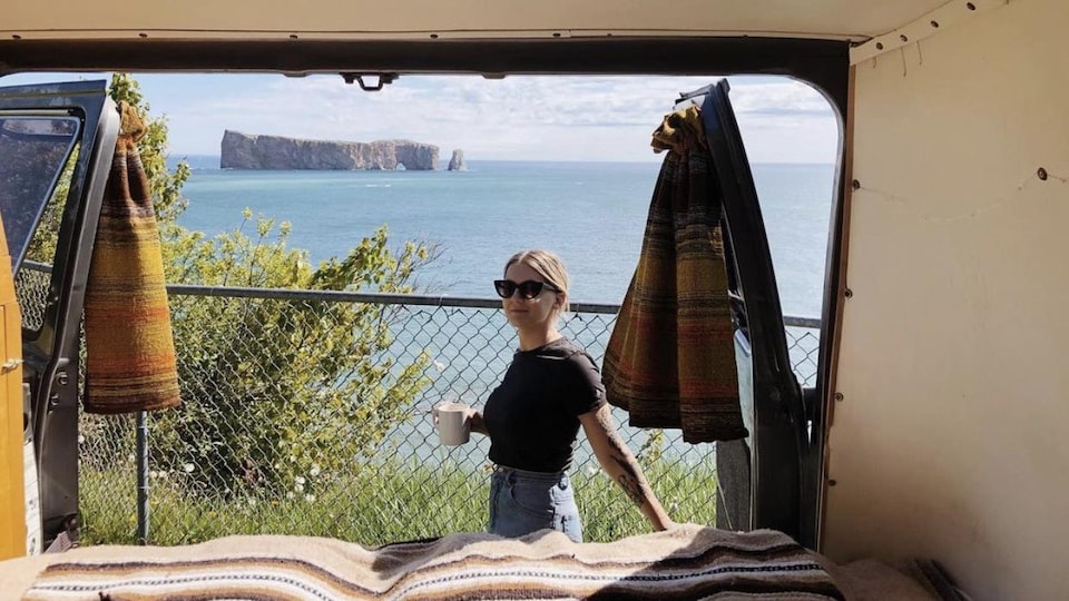 Laurence prend un café devant le rocher Percé. La photo est prise de l'intérieur de sa fourgonnette.