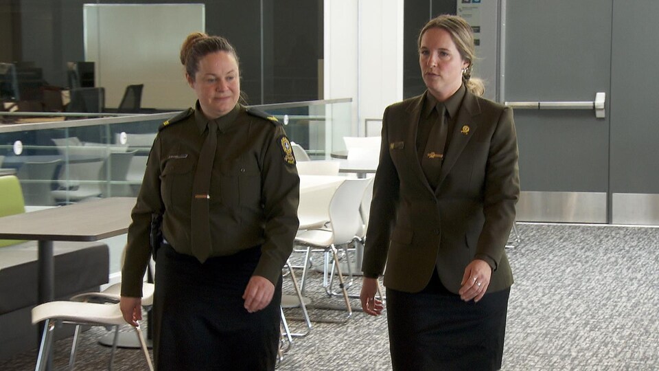 Deux femmes en uniforme marchent l'une à côté de l'autre.