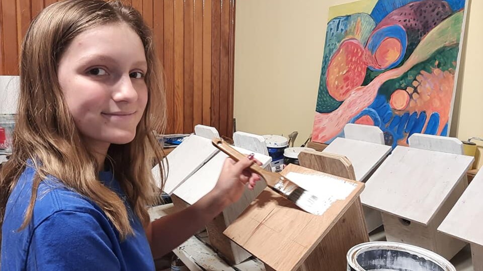 Une jeune fille en train de peindre une boîte