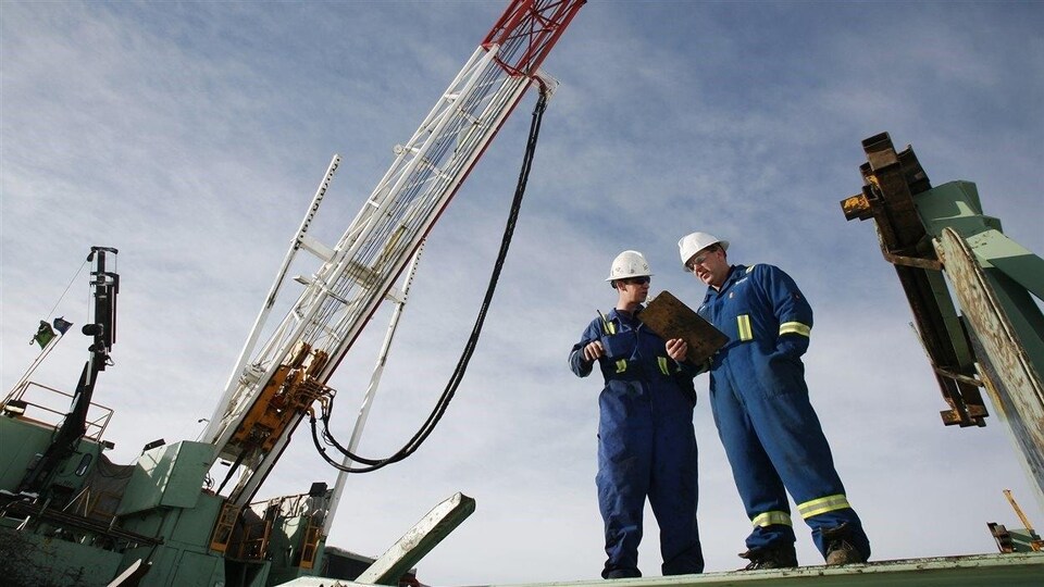 Travailleurs spécialisés devant une exploitation gazière