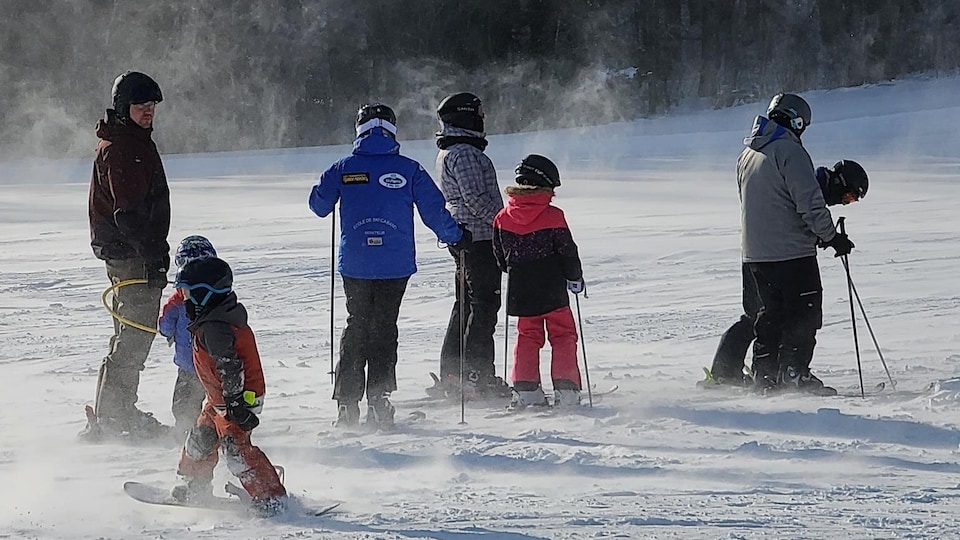 Des skieurs et planchistes sur une pente au Centre de plein air familial de Cabano, un jour de grand froid.