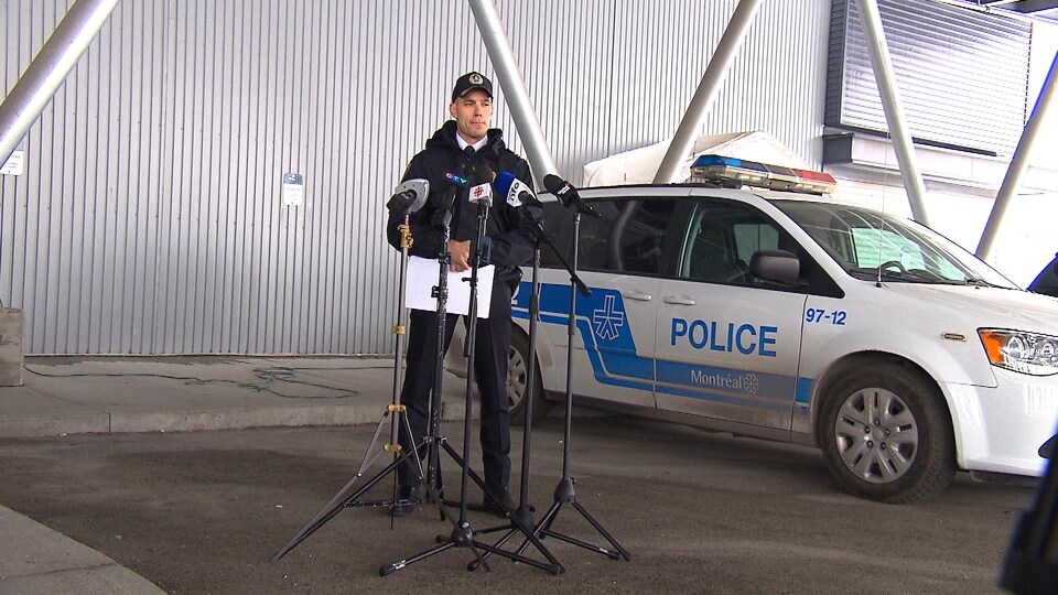 Un officier devant des micros.