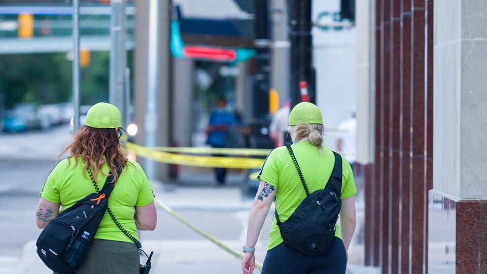 Deux femmes en T-shirt et en casquette jaune fluo.