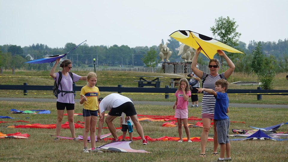 Des participants qui s'apprêtent à faire voler un cerf-volant.