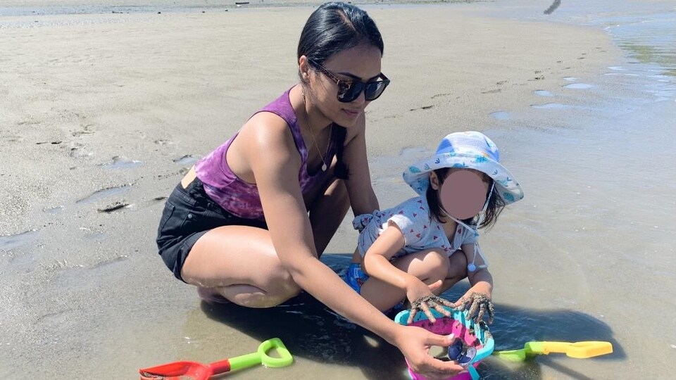 Léa Salisbury et sa fille jouent sur la plage.