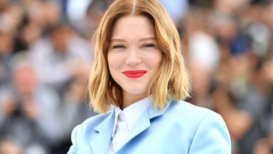 Vêtue de bleu, l'actrice sourit.