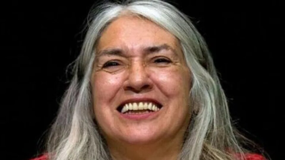 Le portrait de Lee Maracle, une femme aux cheveux longs et gris très souriante.
