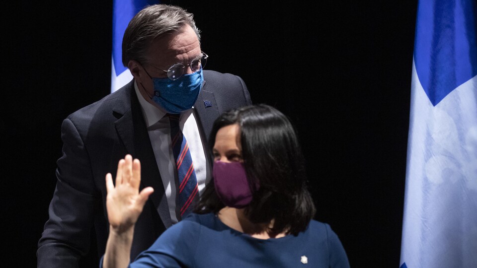 Masqués, François Legault et Valérie Plante s'installent pour la conférence de presse.