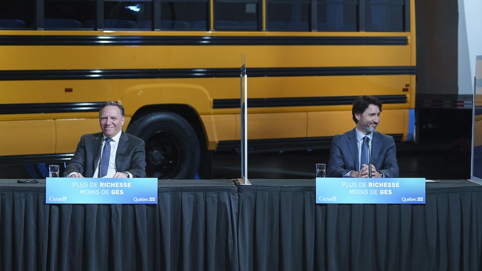 François Legault et Justin Trudeau, souriants et assis durant une conférence de presse.
