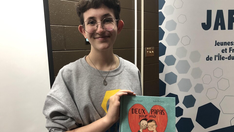 Léo Pendergast tient le livre Deux papas pour moi.