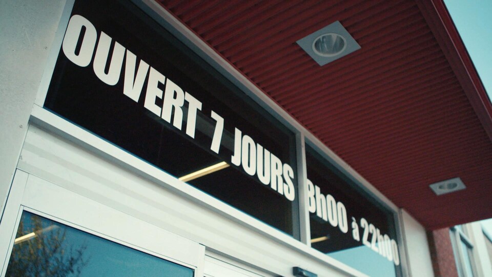 « Ouvert 7 jours 8 h 00 à 22 h 00 », indiqué sur le devant d'un commerce.