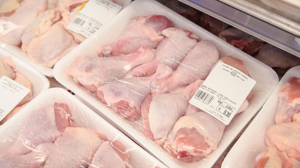 Des pilons de poulet emballés de plastique.