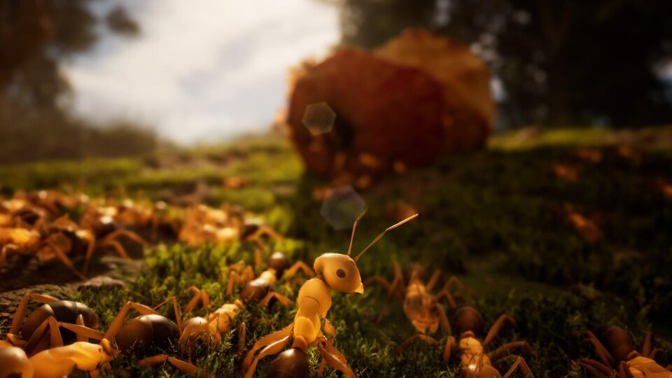 Des fourmis marchent sur une pelouse, et se dirigent vers un trognon de pomme, dans une capture d'écran d'un jeu vidéo. 