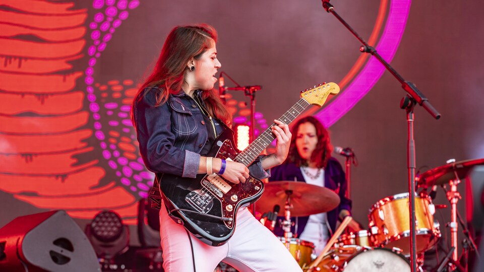 Une guitariste et une batteuse jouent sur scène lors du festival Osheaga