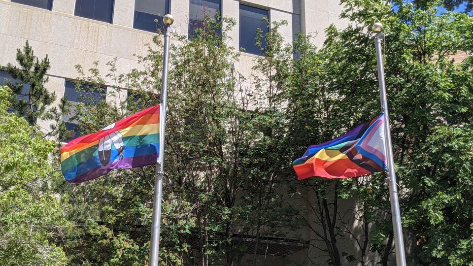 Deux drapeaux LGBTQ+ volent au vent.