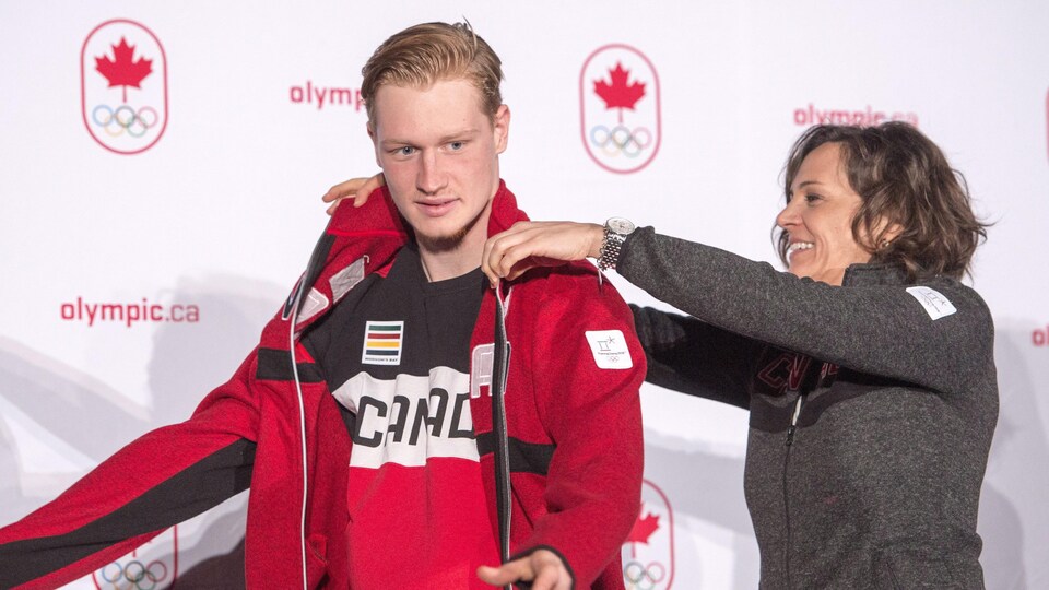 Lewis Irving reçoit la veste de l'équipe olympique canadienne de la chef de mission Isabelle Charest.