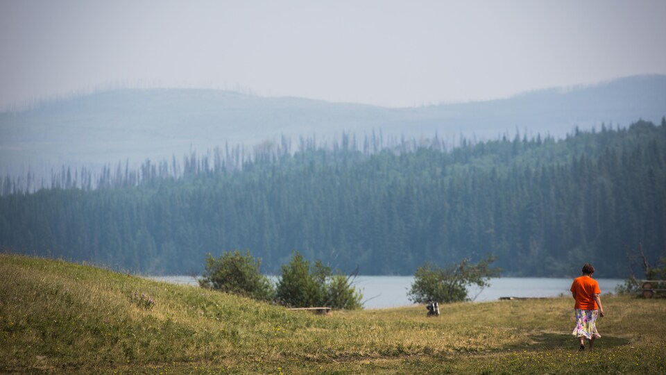 Une personne marche près d'un lac.