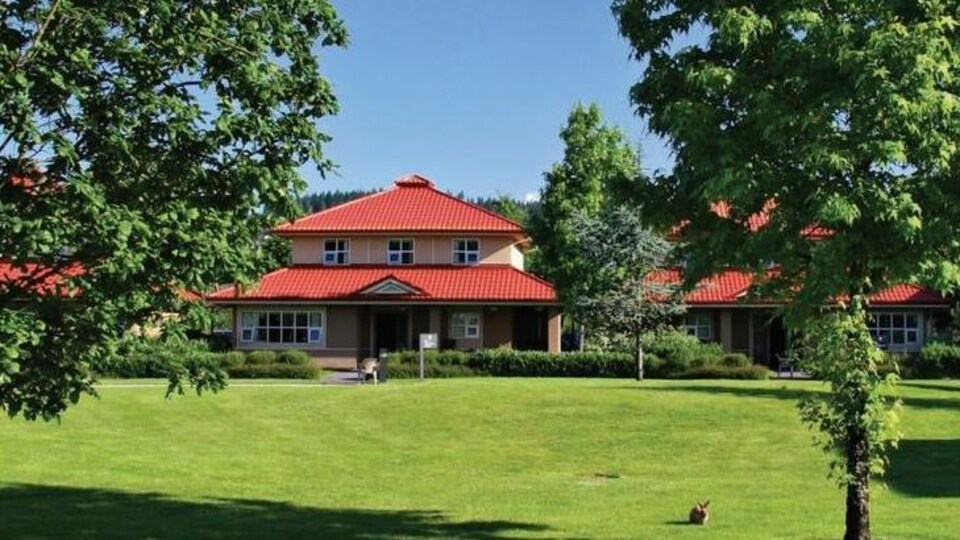 Un bâtiment au toit rouge dans un parc.