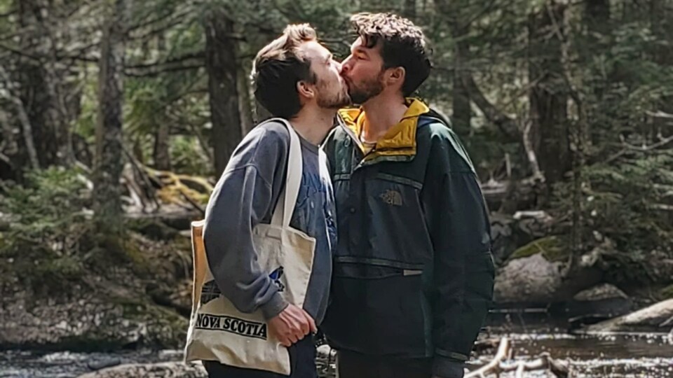Liam Dee et son mari, Jacob Macdonald, s'embrassent dans la forêt.