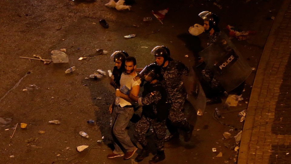 Un manifestant arrêté par plusieurs policiers.