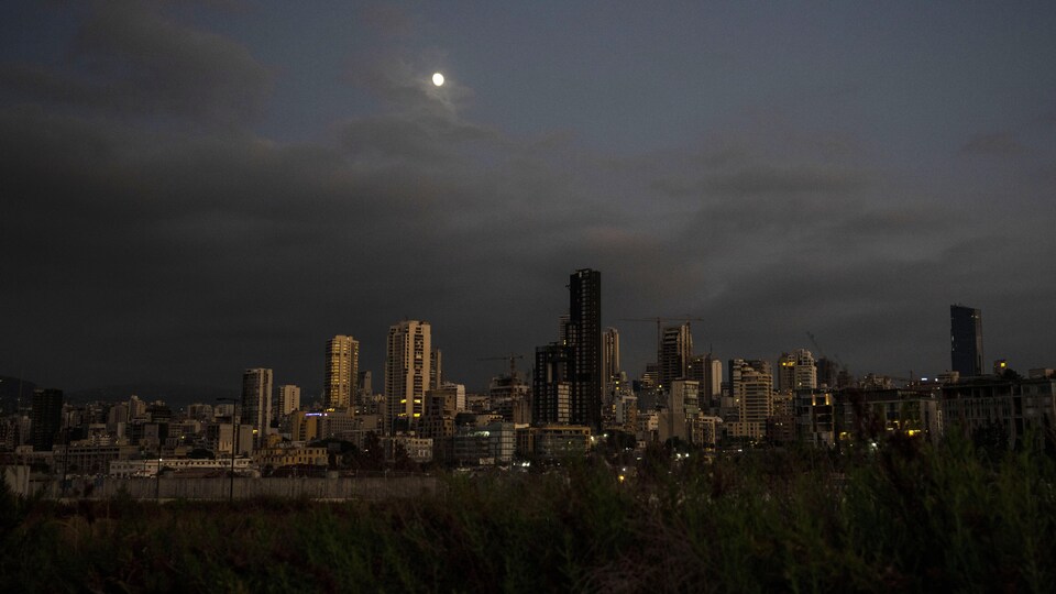La lune se lève sur Beyrouth au Liban, alors que la ville est plongée dans la pénombre.