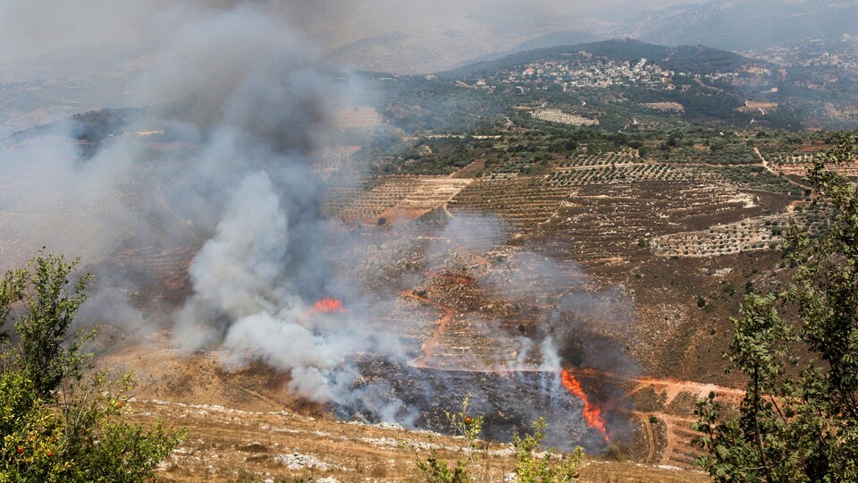 De la fumée et des flammes dans un champ à la suite de bombardements israéliens au Liban le 4 août 2021.