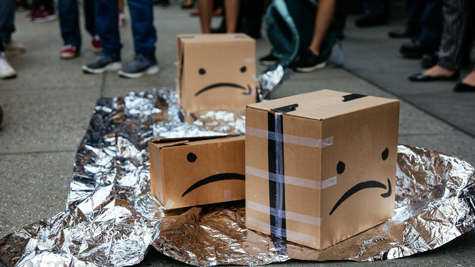 Des boîtes avec le logo d'Amazon trafiqué pour ressembler à des visages fâchés. 