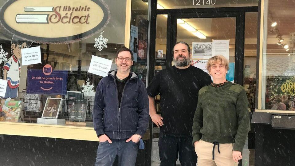 Trois hommes se tiennent debout devant la librairie. 