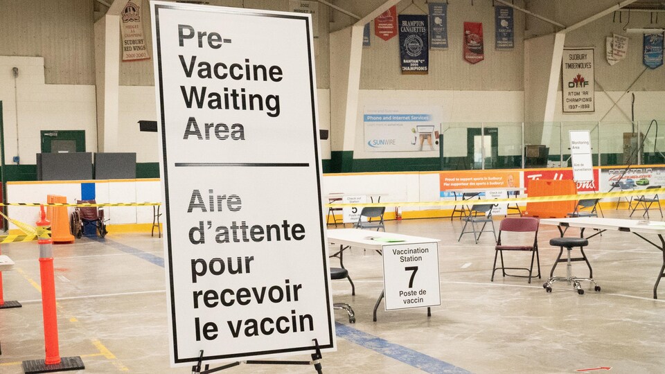 Des tables dans un aréna où des gens seront vaccinés.