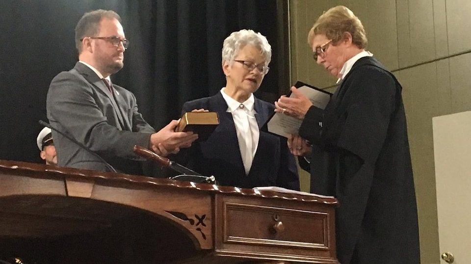 Antoinette Perry prête serment à la reine, une main sur la bible. 