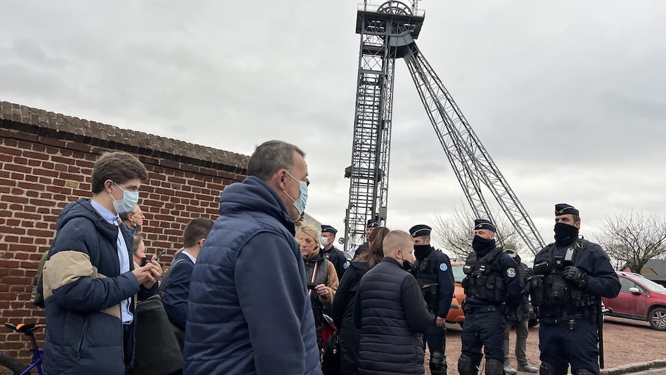 Des gens tentent de s'approcher d'Emmanuel Macron.