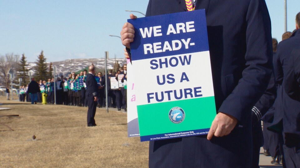 Sur une affiche en anglais il est écrit : Nous sommes prêts, montrez-nous un avenir. 