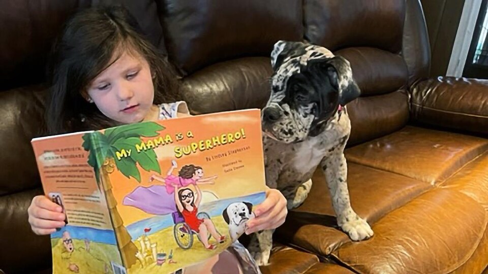 Ella lit le livre pour enfants « My Mama Is a Superhero » écrit par sa mère Lindsey Stephenson.