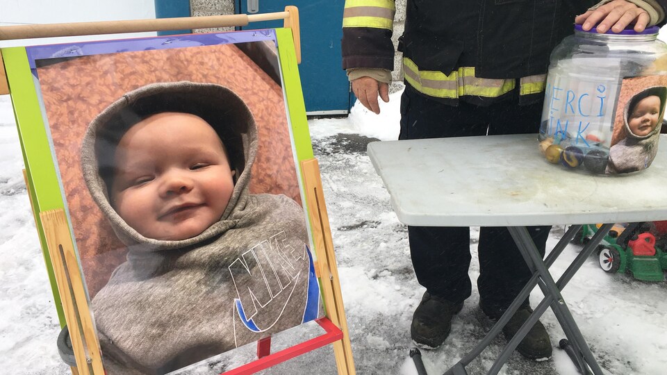 La pancarte d'un bambin et un pot à coté pour récolter de l'argent.