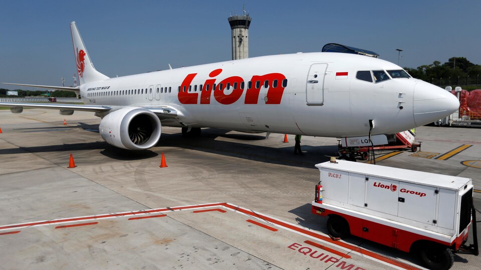 Les lettres rouges de la compagnie se dessinent sur le fond blanc de l'avion.