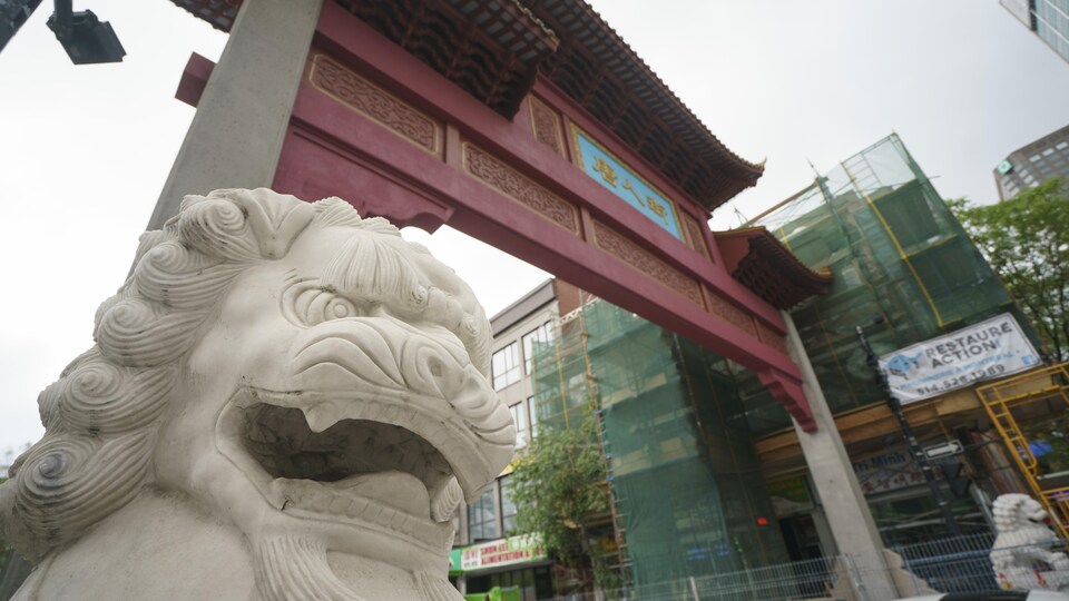 Gros plan sur la statue de lion au pied des portes du Quartier chinois, à Montréal.