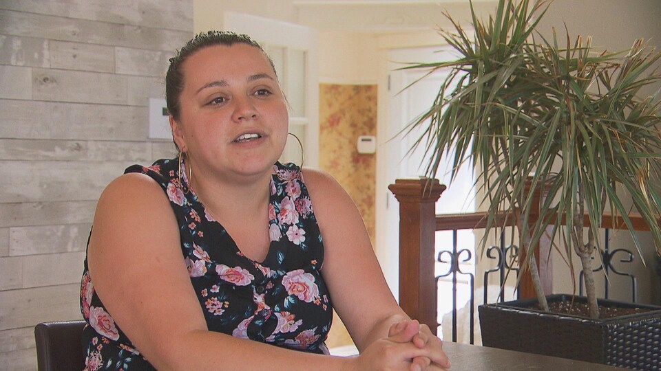 Lisa-Marie Coocoo, directrice du Centre Opoho, est assise à une table et répond aux questions d'un journaliste.