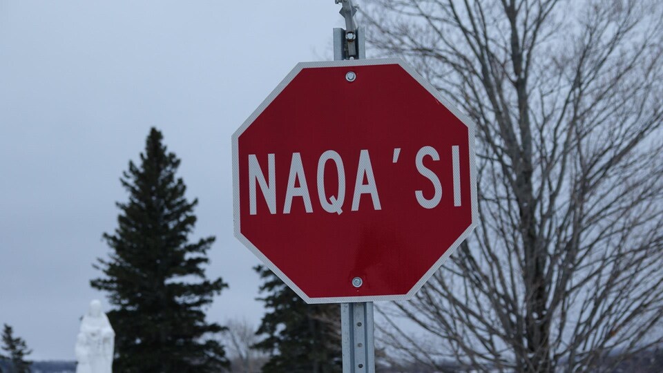 Un panneau d'arrêt avec le mot « naqa'si ».
