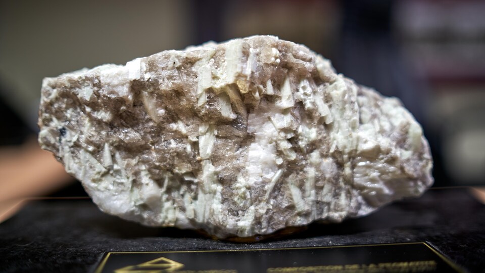 Gros plan d'une roche avec des fragments de lithium en brun.
