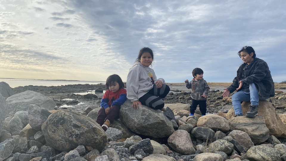 Une femme crie et ses trois jeunes enfants.