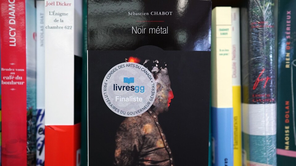 Le livre Noir métal sur une tablette de librairie.