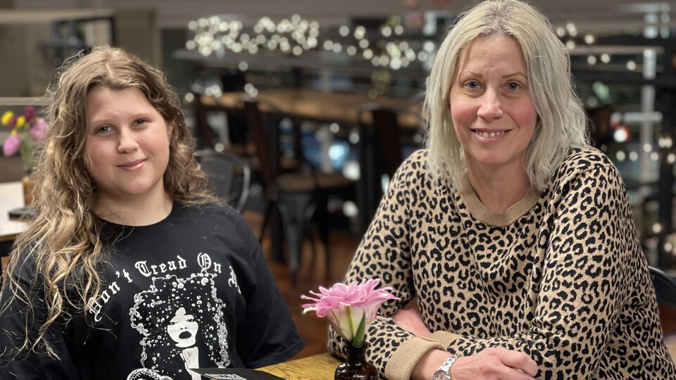 Une mère et sa fille assises à une table.