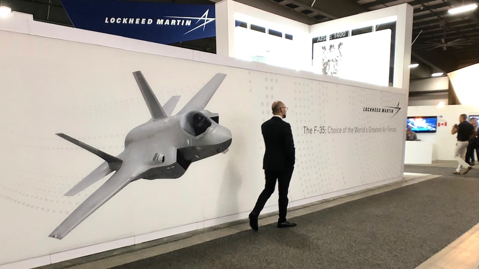 Une photo d'un homme qui passe devant un panneau publicitaire du géant américain de l'aérospatiale, Lockheed Martin.