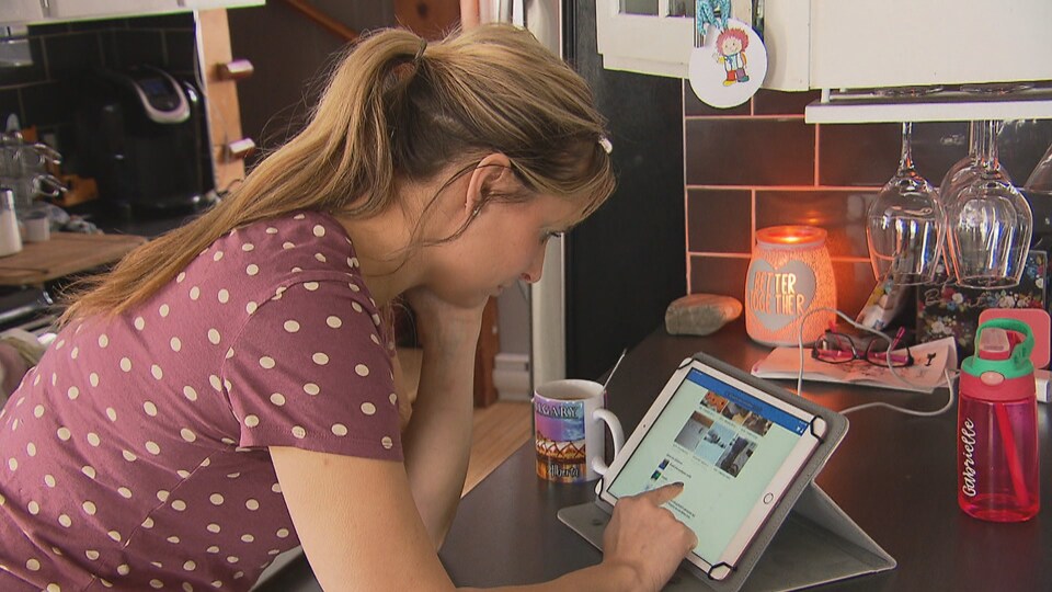 Valérie Girouard est penchée sur sa tablette électronique.