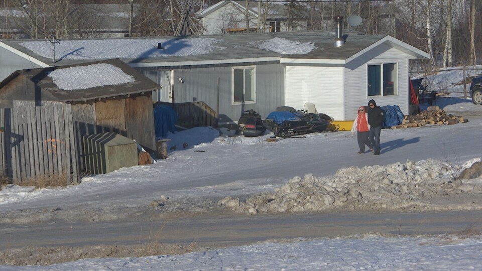 Des habitants marchent dans une ruelle de la communauté de Southend, dans le nord de la Saskatchewan.