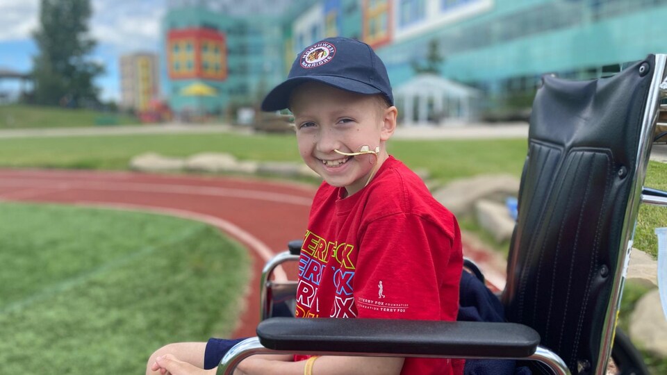 Loic Germaine est dans un fauteuil roulant, devant l'hôpital pour enfants de l'Alberta à Calgary.