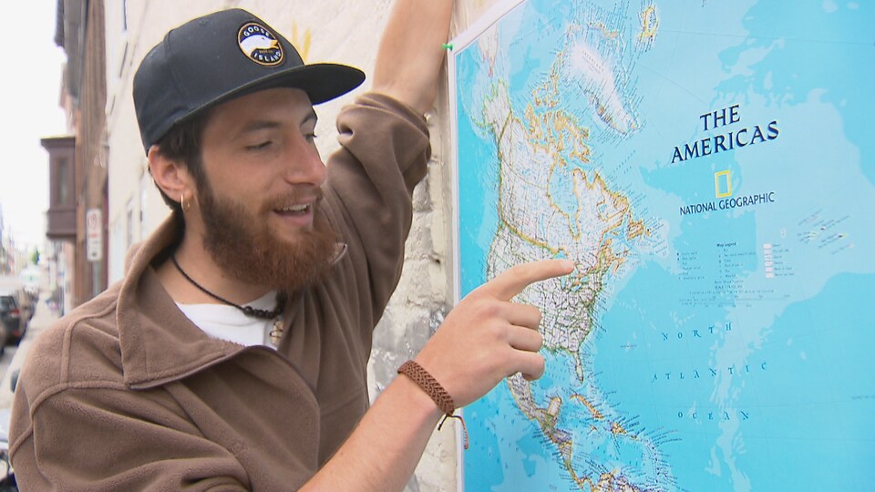 Louis Astoux montre du doigt le Québec sur une carte des amériques