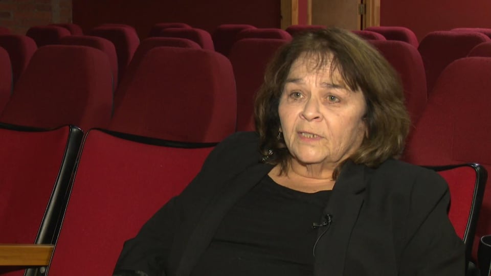 Louise Lalonde donne un entrevue dans une salle de projection.