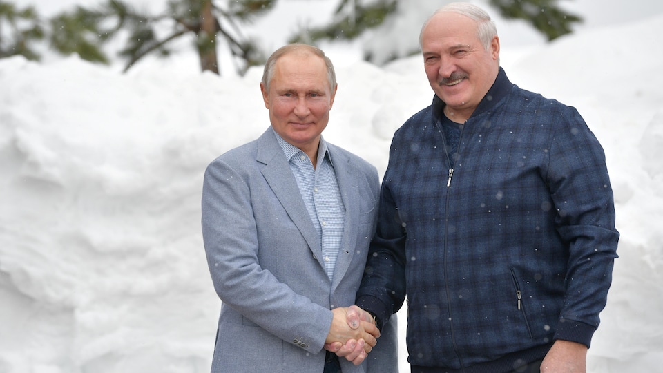 Vladimir Putin y Alexander Lukashenko se dan la mano.